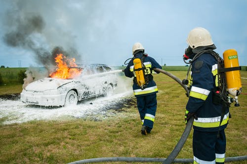 两名消防员喷在火焰车上 · 免费素材图片