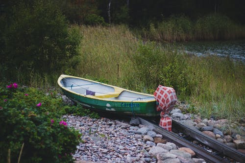 湖附近的绿色和黄色独木舟 · 免费素材图片