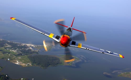 银黄色红色和黑色喷气式飞机在白天飞行 · 免费素材图片