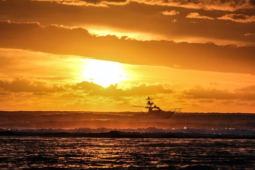 黄金时段海上渔船的剪影摄影 · 免费素材图片