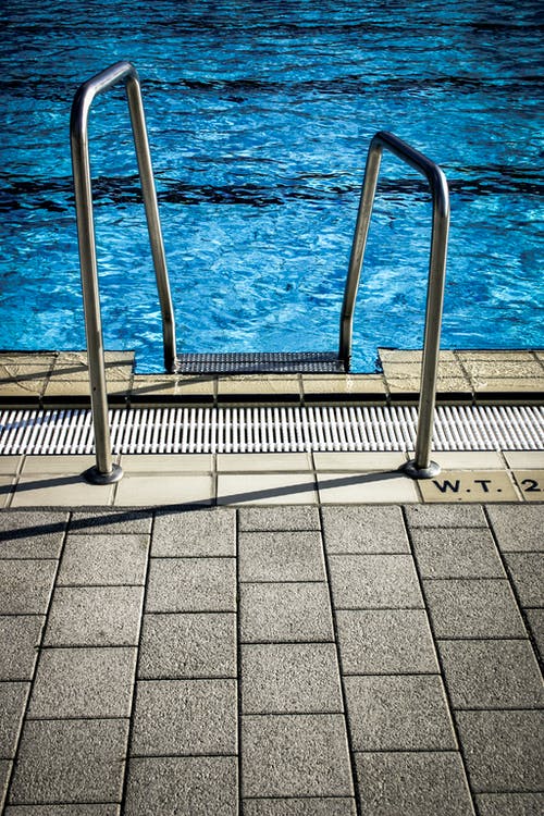 游泳池附近的白色金属栏杆 · 免费素材图片
