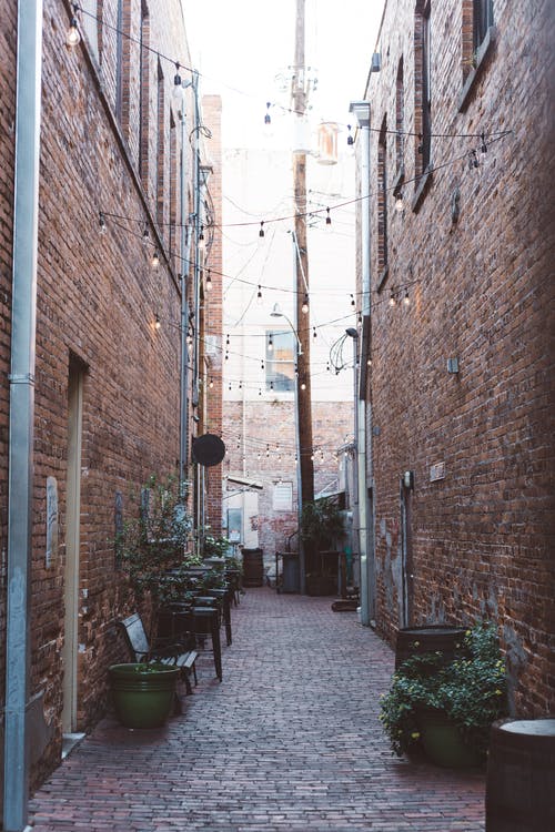 棕色砖砌的房屋之间的街巷 · 免费素材图片