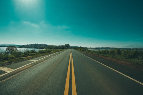 草与水域之间的道路全景摄影 · 免费素材图片