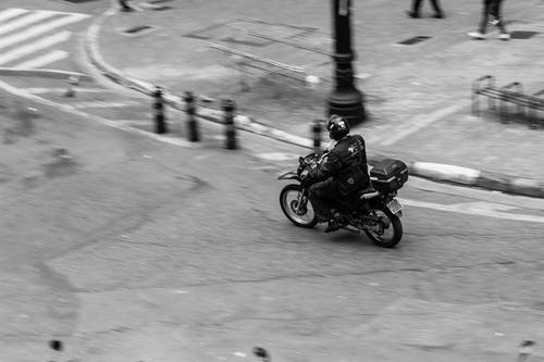 在岗位和人附近驾驶摩托车的人 · 免费素材图片