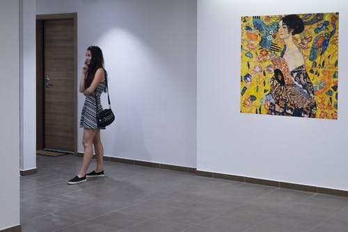 女人站在白墙上与多彩多姿的女人绘画 · 免费素材图片