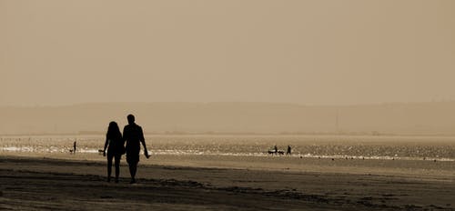 剪影男人和女人在海边散步 · 免费素材图片