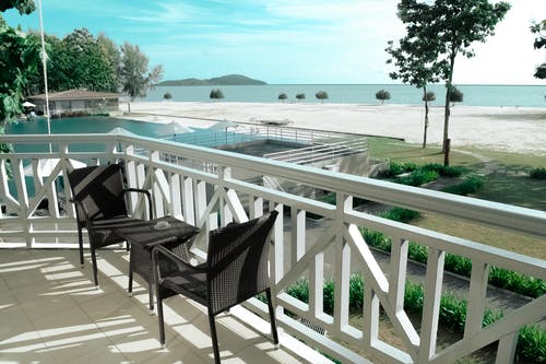 黑色柳条小酒馆设置在海洋附近的白色露台上 · 免费素材图片