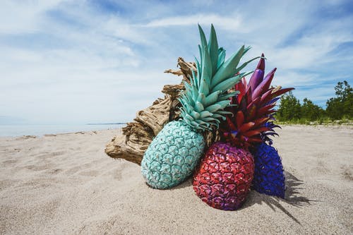 在沙子上的三个什锦菠萝 · 免费素材图片
