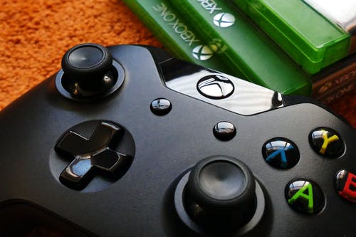 Xbox One控制器旁边三个xbox One机箱 · 免费素材图片