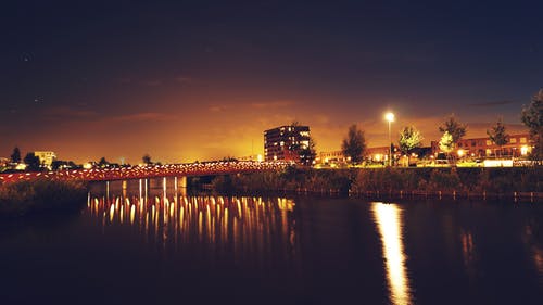 夜间跨建筑物的水桥 · 免费素材图片
