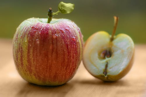 棕色表面上的红色和绿色苹果 · 免费素材图片