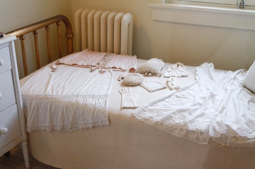 白色床垫上的白色无袖连衣裙 · 免费素材图片