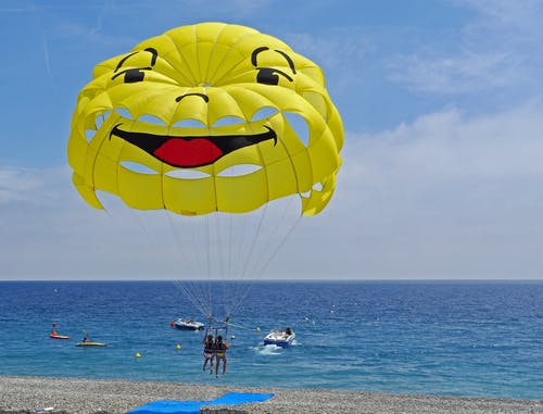 两人在海洋附近滑翔伞 · 免费素材图片