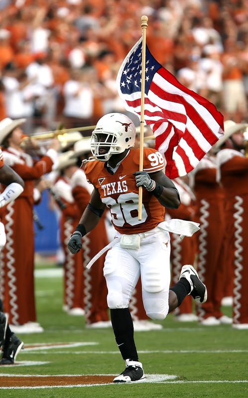 Nfl球员在球场上拿着美国国旗 · 免费素材图片
