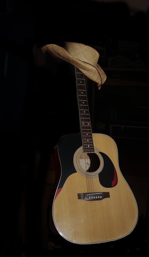 吉他上的棕色帽子 · 免费素材图片