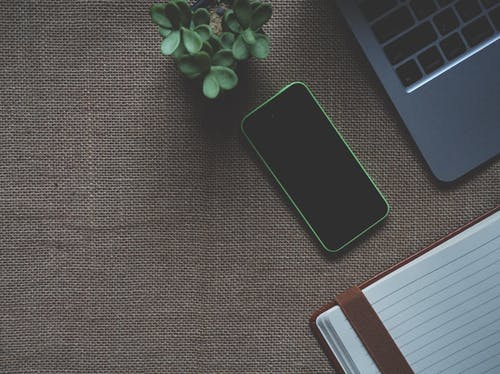 Macbook附近的绿色iphone 5c · 免费素材图片