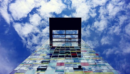 白天白云和蓝天下玻璃建筑的低角度摄影 · 免费素材图片