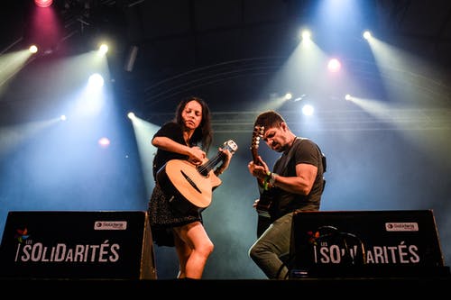 男人和女人在团结的舞台上弹吉他 · 免费素材图片