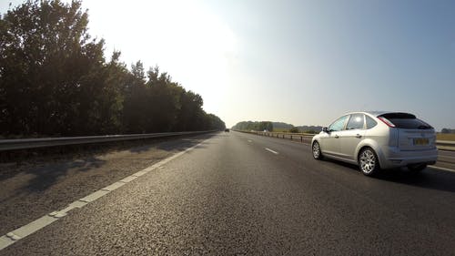 银色福特福克斯5门掀背车在公路上超速行驶 · 免费素材图片