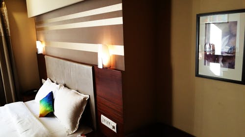空床，木制床头板和灯 · 免费素材图片