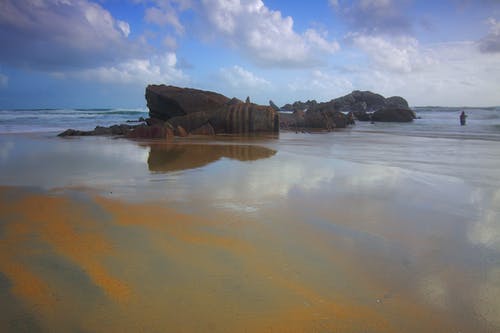 海岸线旁边的棕色岩层 · 免费素材图片