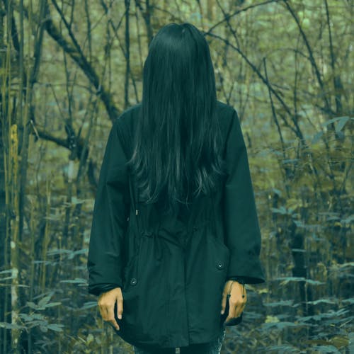 站在森林里的黑外套的人 · 免费素材图片