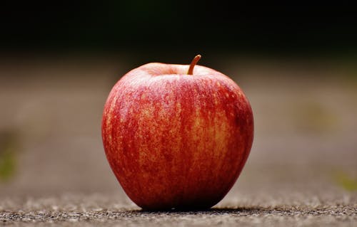 红苹果在灰色路面上的浅焦点摄影 · 免费素材图片