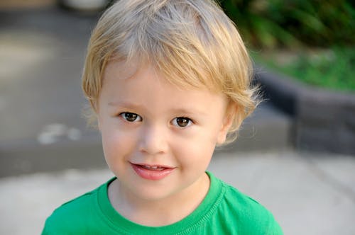 绿色圆领上衣的微笑男孩 · 免费素材图片