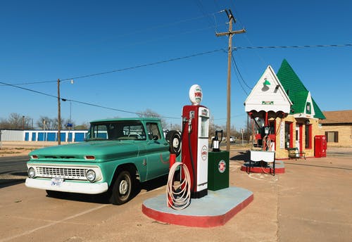 加油站旁的绿色单人驾驶皮卡车 · 免费素材图片