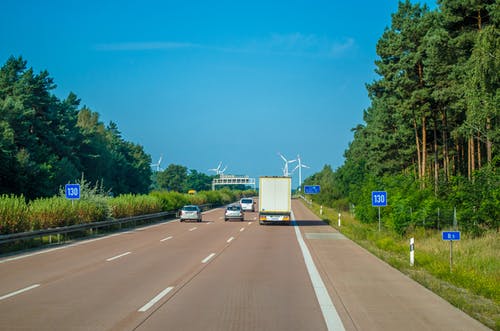 车辆在高速公路上驶向风力涡轮机 · 免费素材图片