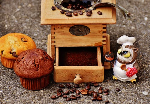 棕色木制咖啡豆研磨机和两个松饼 · 免费素材图片