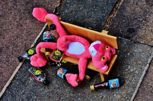 棕色长椅上的粉红色豹毛绒玩具 · 免费素材图片