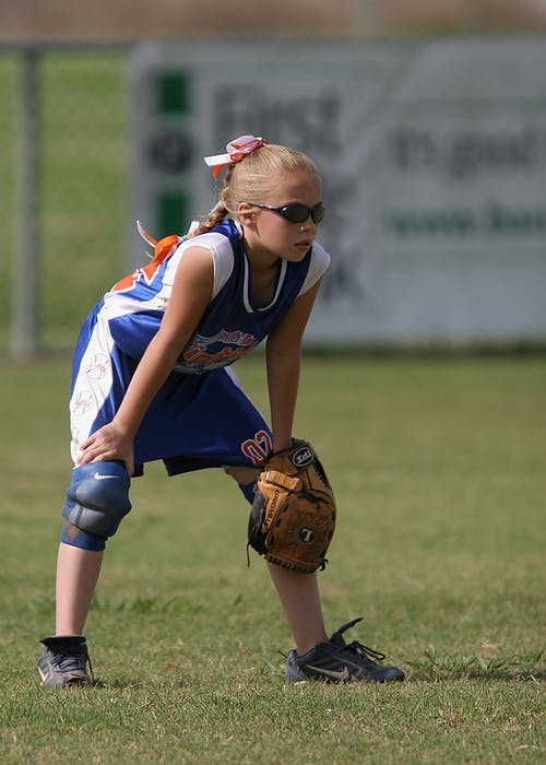 女孩抱着棕色皮革棒球手套 · 免费素材图片