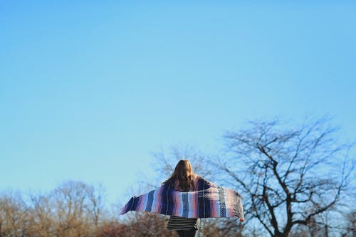 围巾在蓝蓝的天空下的女人 · 免费素材图片