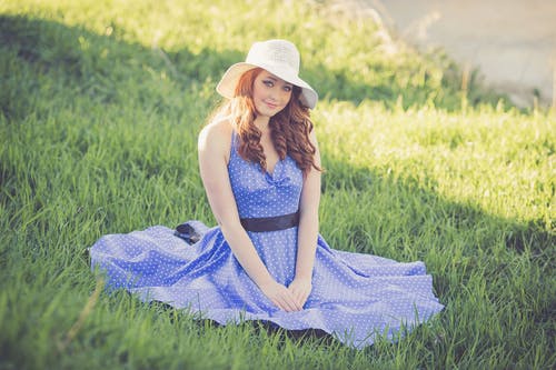 在草丛中一个微笑的年轻女子的画像 · 免费素材图片