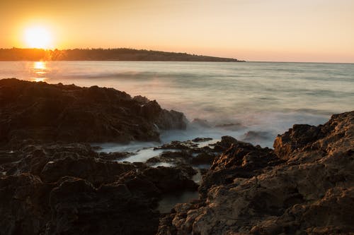 日落期间大海对戏剧性天空的风景 · 免费素材图片
