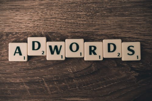 棕色木制表面上拼字游戏形成adwords · 免费素材图片