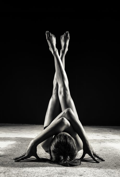 抬起双腿躺在地板上的女人 · 免费素材图片