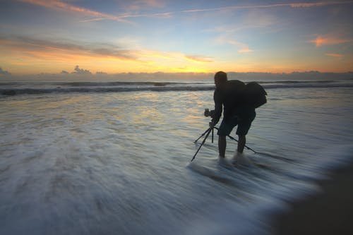 男人在黄金时段拍照的海洋 · 免费素材图片