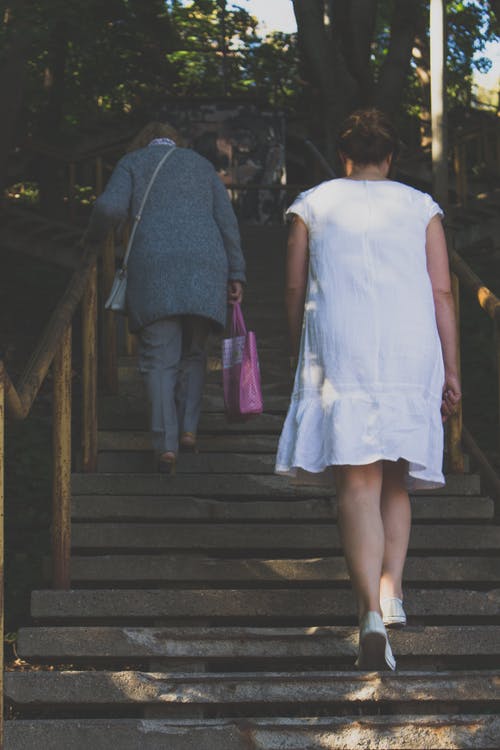 穿白色连衣裙，爬楼梯的女人 · 免费素材图片
