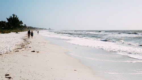 在沙滩上行走的人 · 免费素材图片