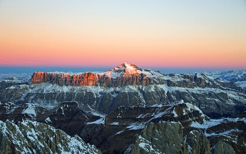 日落时白雪覆盖的山脉的景色 · 免费素材图片