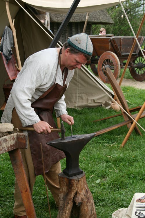 男子手持铁锤在铁砧前 · 免费素材图片