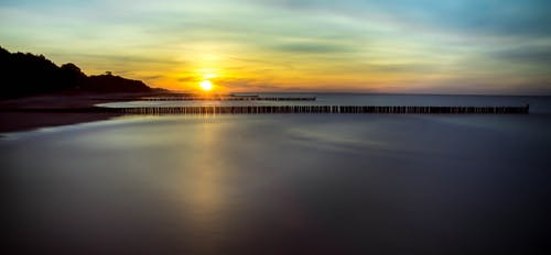 多云的天空下平静的水体景观摄影 · 免费素材图片