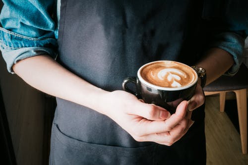 女人抱着杯卡布奇诺咖啡 · 免费素材图片