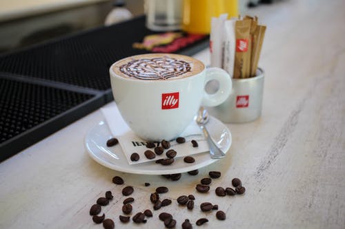 白色陶瓷杯碟与咖啡豆 · 免费素材图片