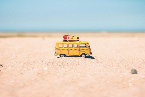 黄色压铸微型面包车，棕色沙滩 · 免费素材图片