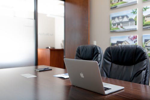 在黑色的前椅子上的木桌上的银色macbook · 免费素材图片