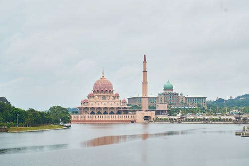 水体附近的塔旁边的棕色清真寺 · 免费素材图片