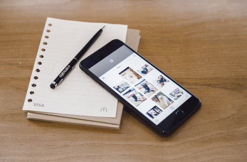 白色笔记本上的黑色iphone 7 · 免费素材图片